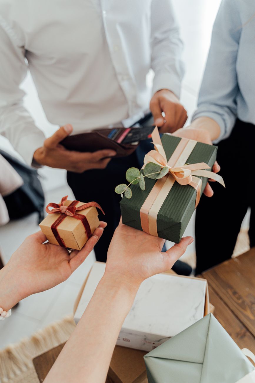 a person holding green and brown gift box